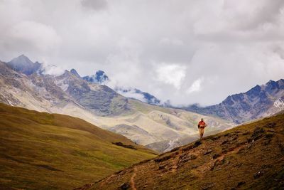 Man walking on mountain against sky