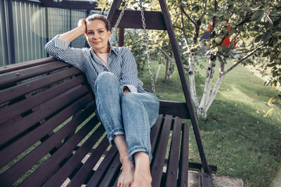Portrait of young woman sitting on bench