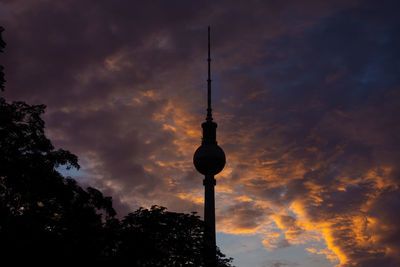 Low angle view of communications tower against sky during sunset