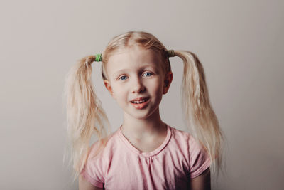 Portrait of smiling girl against colored background