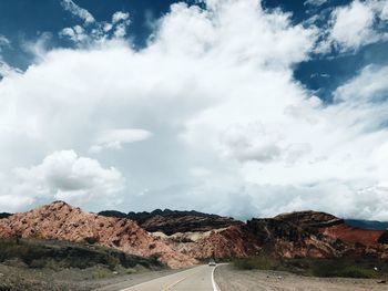 Road by mountain against sky