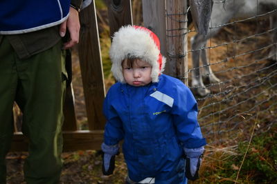 Rear view of boy standing against wall