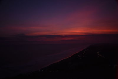 Scenic view of sea against dramatic sky during sunset