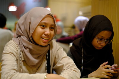 Portrait of young woman having discussion at cafe