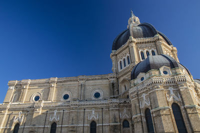 Low angle view of historic building against blue sky