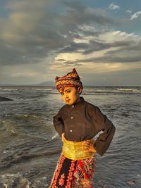 Boy standing at beach against sky