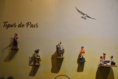 Group of people at birds on wall