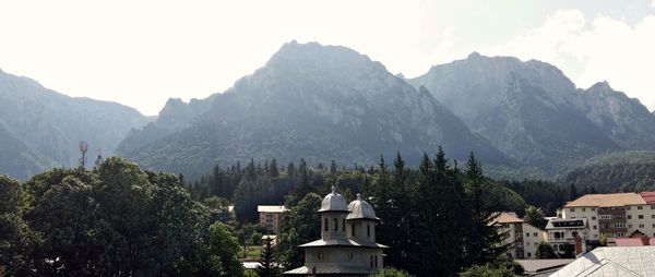 Scenic view of mountains and buildings against sky