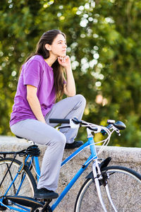 Side view of woman with bicycle