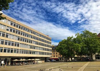 Buildings in city against cloudy sky