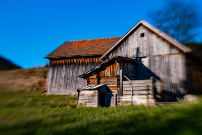 Barn on field against blue sky