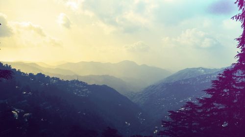 High section of mountain range against clouds
