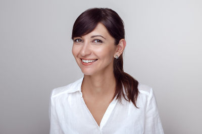 Portrait of smiling woman against gray background