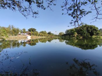 Scenic view of lake by trees against sky