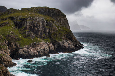 Rock formations by sea against sky