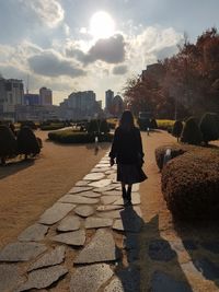 Rear view of woman walking on street in city