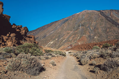 Scenic view of rocky mountains against clear blue sky