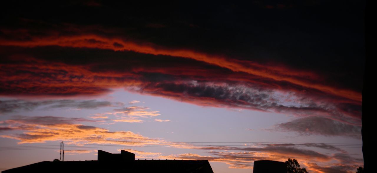 LOW ANGLE VIEW OF SILHOUETTE BUILDINGS AGAINST DRAMATIC SKY