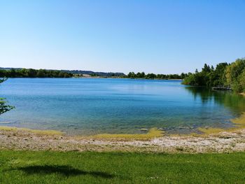 Scenic view of lake against clear blue sky