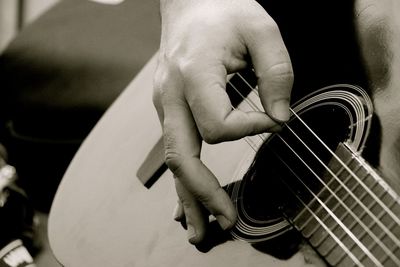 Cropped image of person playing guitar