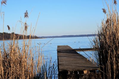 Pier on lake against clear sky