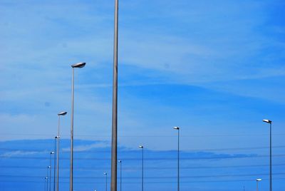 Low angle view of street light against blue sky