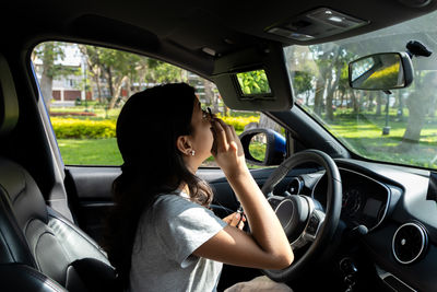 Rear view of woman sitting in car
