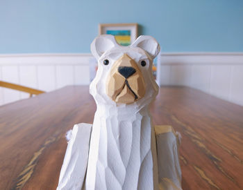 Dog looking away while sitting on wood at home