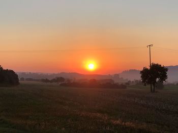 Scenic view of field against sky during sunset