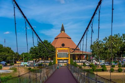 Bridge leading towards building against sky