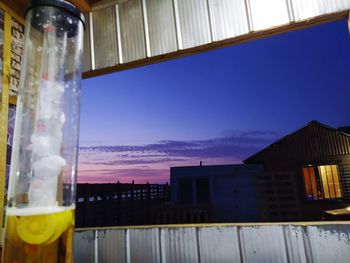 Glass of building against sky during sunset