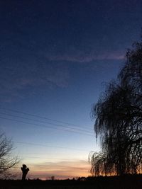 Low angle view of silhouette trees on field against sky