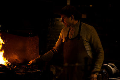 Latvian blacksmith working with open fire in furnace. the blacksmith forging hot iron in workshop