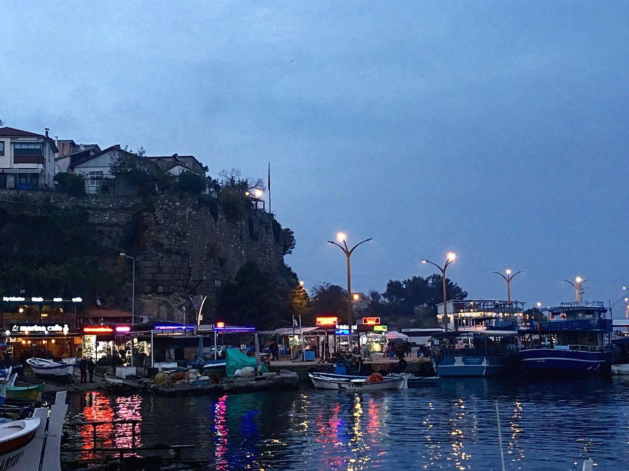 BOATS MOORED AT HARBOR