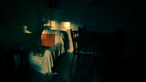 Man sitting on chair in illuminated building