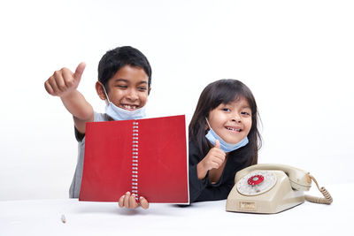 Portrait of smiling siblings against white background