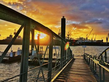 Pier on bridge against sky during sunset