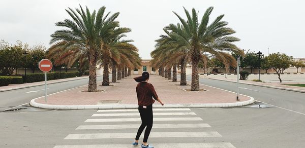 Rear view of woman walking on road in city