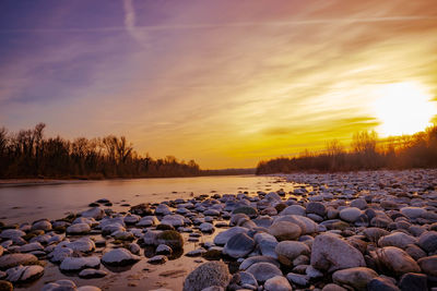 Surface level of stones against sky during sunset