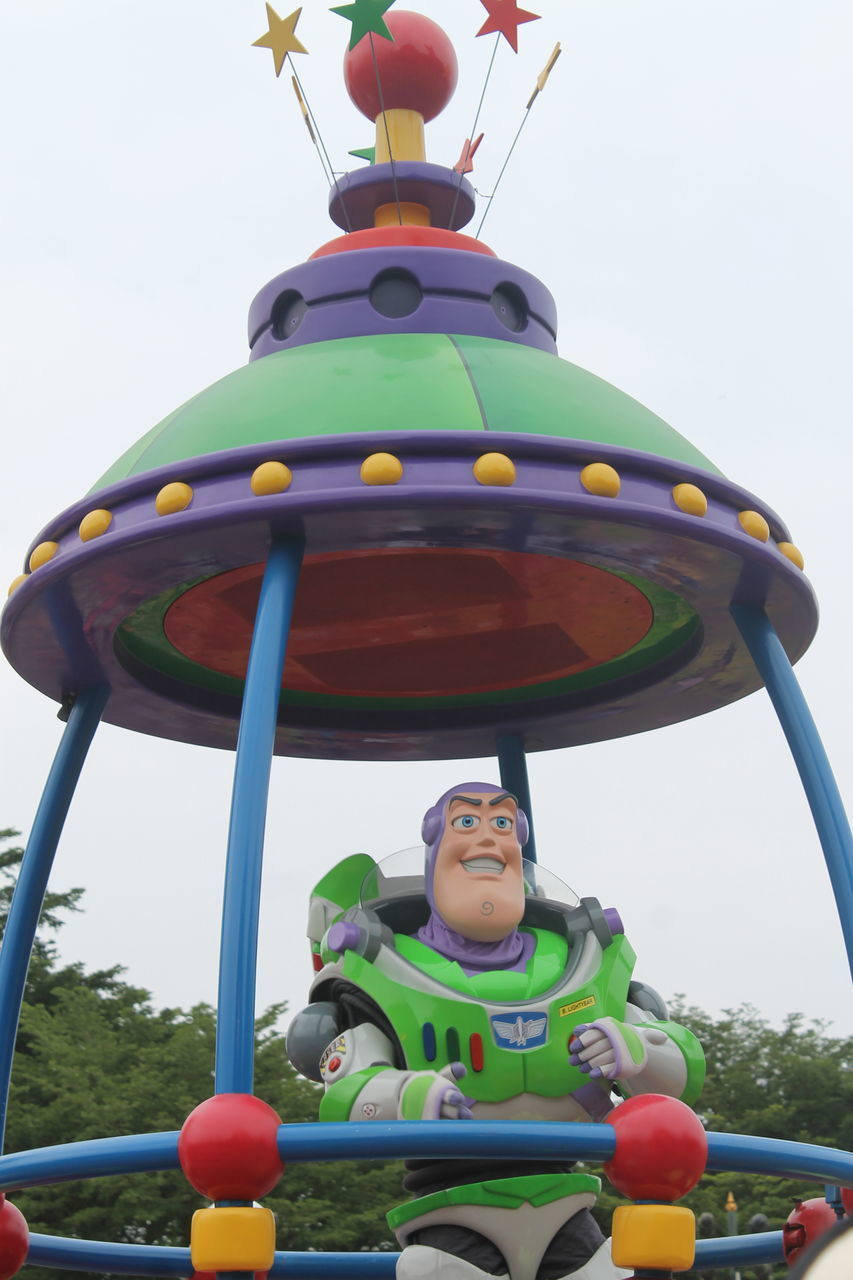 LOW ANGLE VIEW OF BOY AT AMUSEMENT PARK