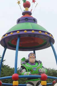 Low angle view of boy at amusement park against sky