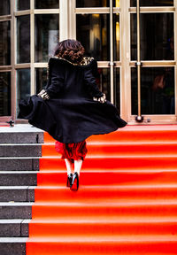 Rear view of woman against red window