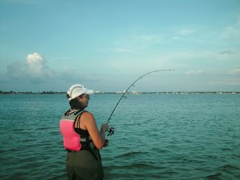 Woman fishing in sea