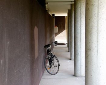 Bicycle leaning on wall of building