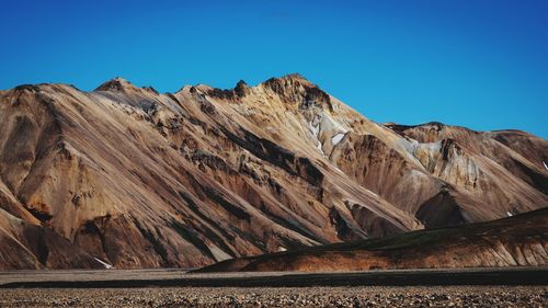 Scenic view of mountains against clear blue sky