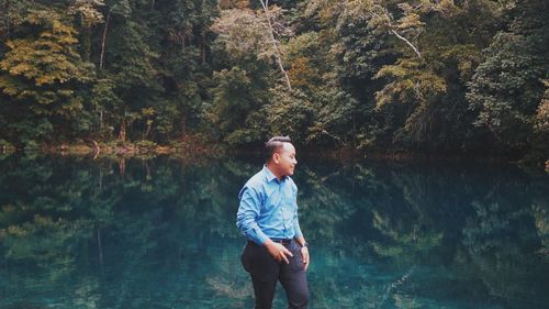 Man walking by lake in forest