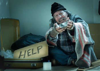 Full length of young man sitting on wall