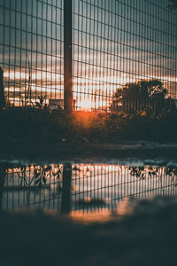 Fence by railing against sky during sunset