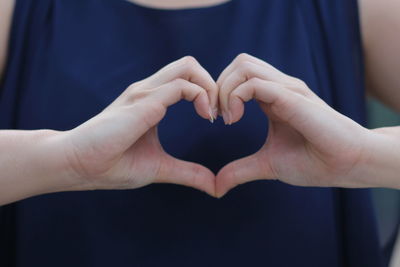 Close-up of couple holding heart shape