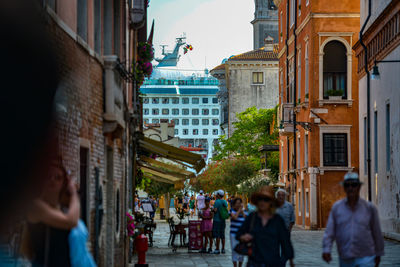 People walking on street amidst buildings in city